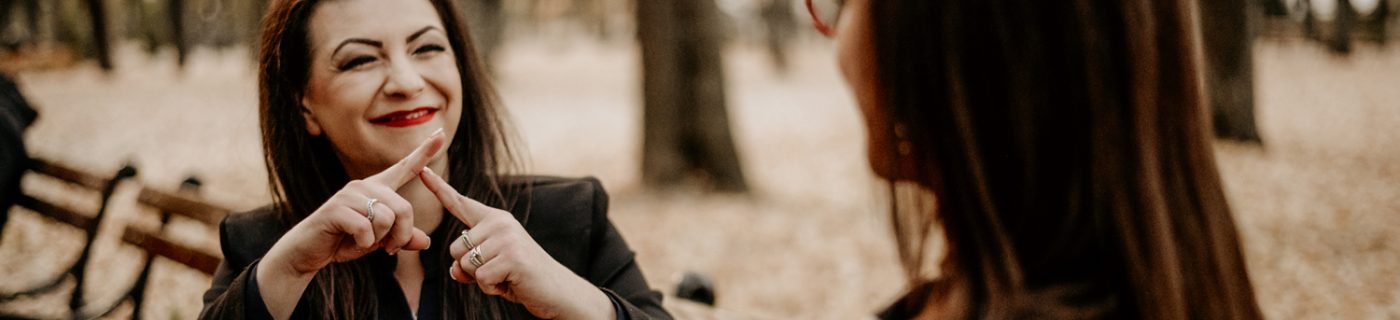 woman signing to another woman